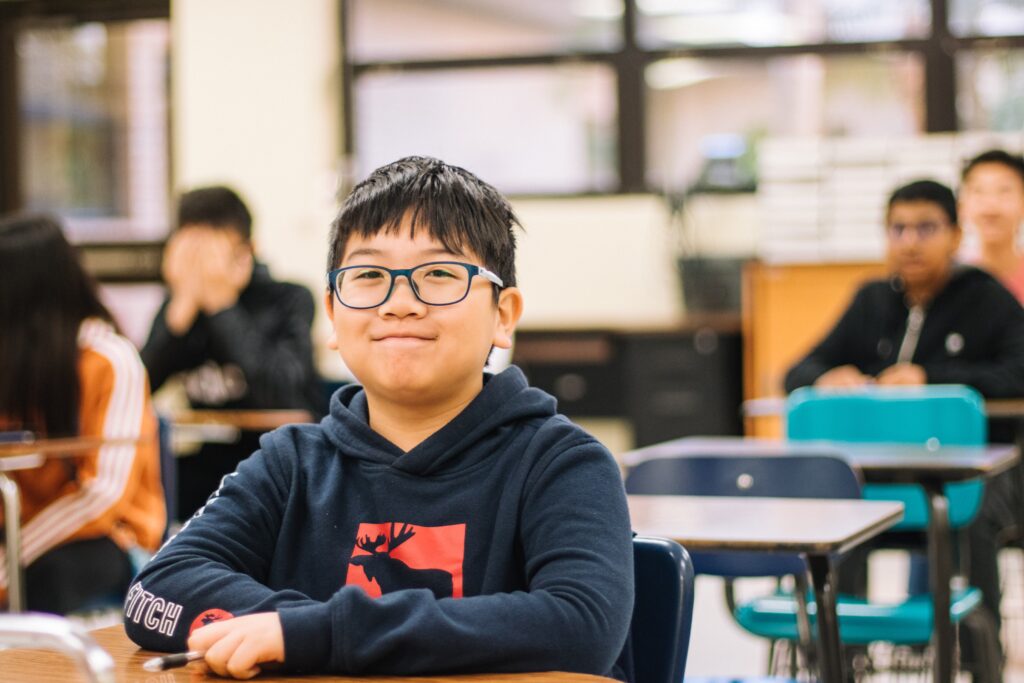 young asian school boy smiling in classroom