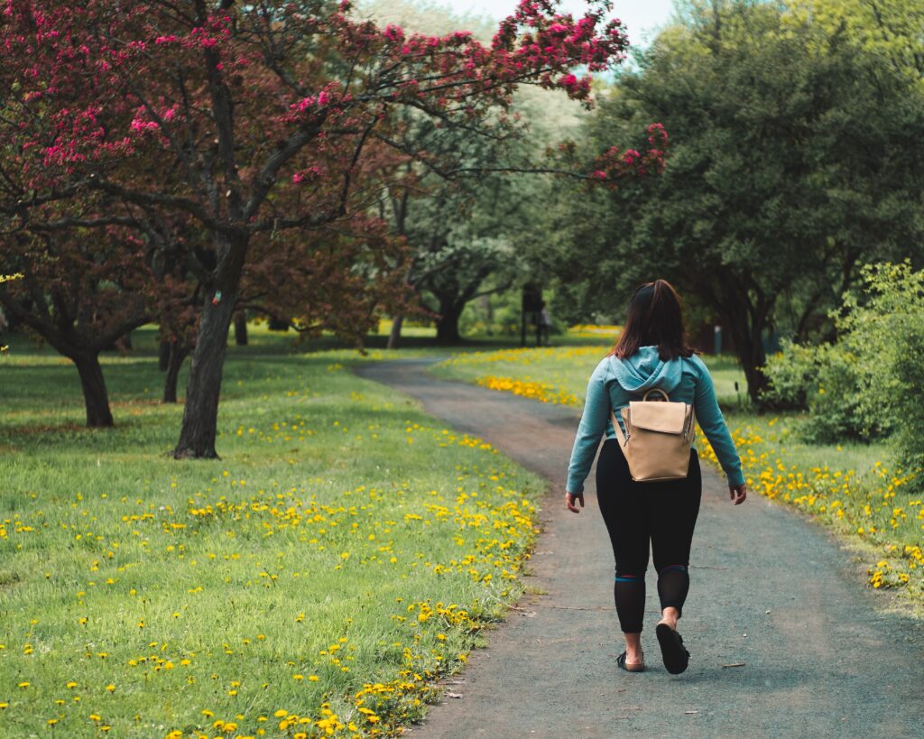 a woman walking along a path in a park