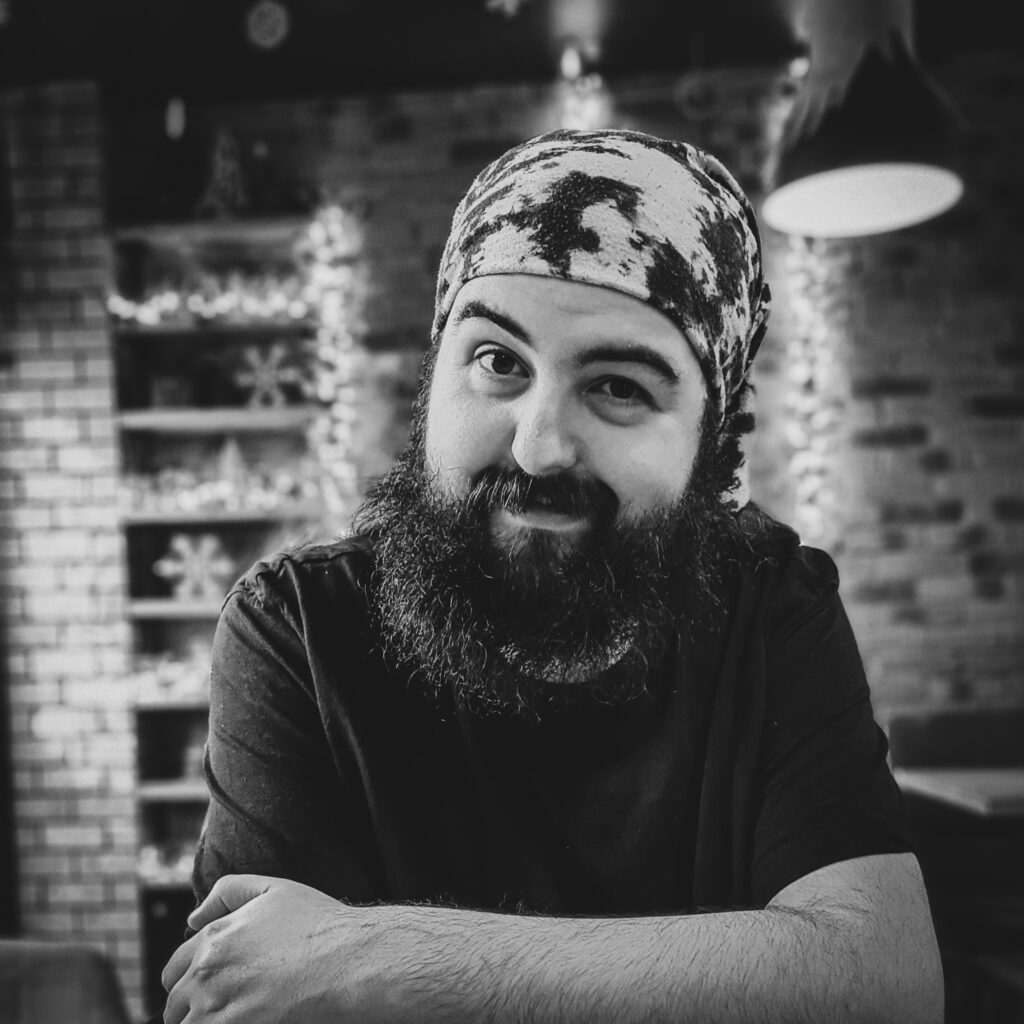A black and white image of John Duddy who is part of the ARFID Connect group. He has a beard, wears a t-shirt and bandana.